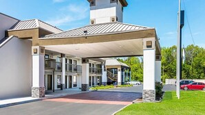 A hotel with a covered entrance, multiple floors, and a central tower. - Farragut Inn & Suites (Farragut)