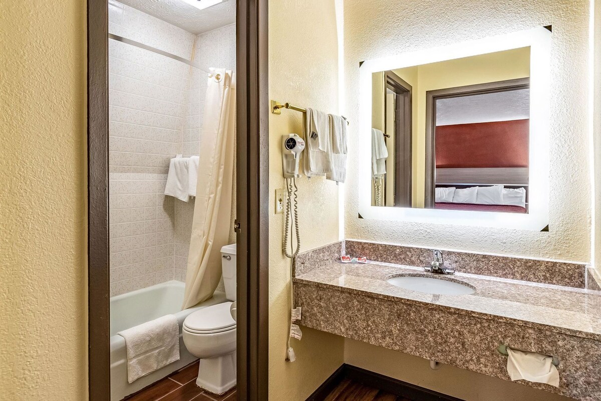 A bathroom with a shower, toilet, and sink.