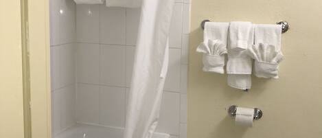 A bathroom with a bathtub, a toilet, and a shower curtain.