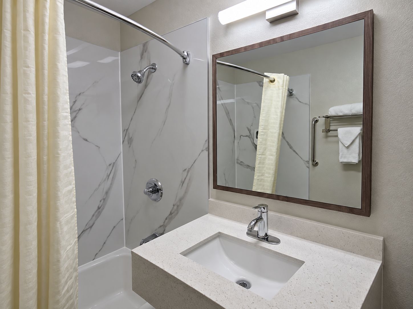 A bathroom with a shower, a sink, and a mirror.