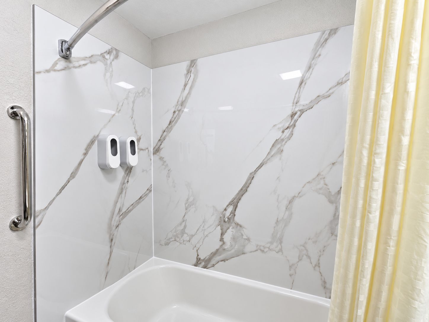 A bathroom with a shower, a toilet, and a hand dryer.