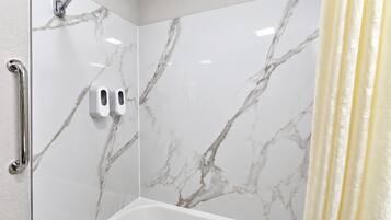 A bathroom with a shower, a toilet, and a hand dryer.