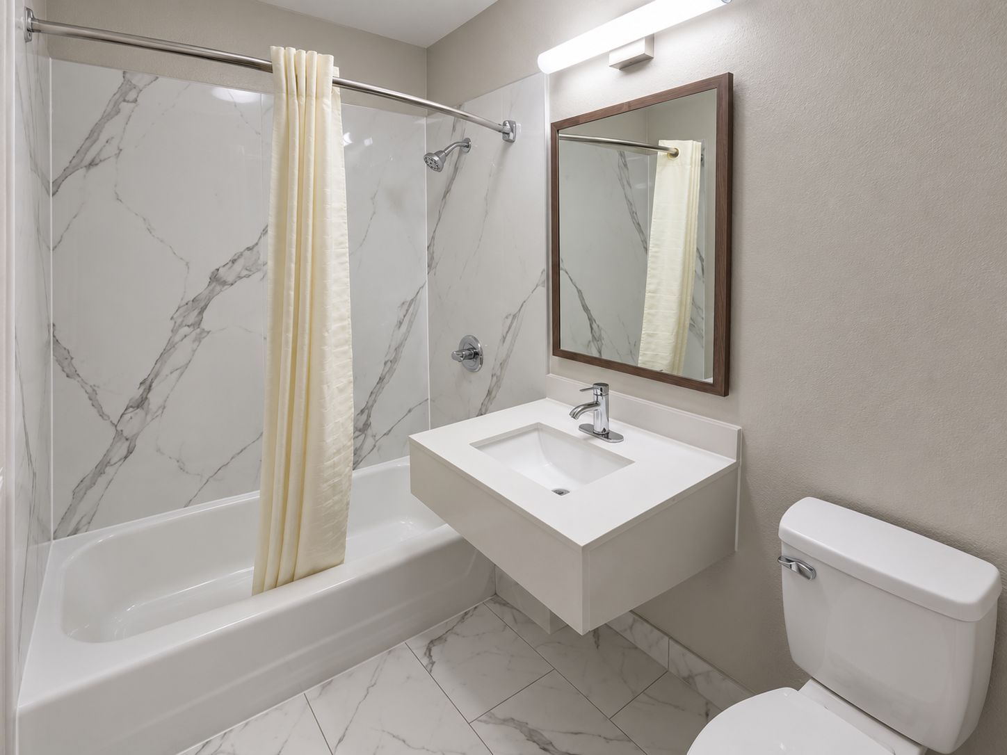 Un baño con bañera, lavamanos e inodoro.
