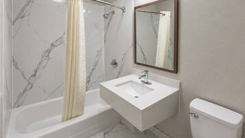 Un baño con bañera, lavamanos e inodoro.
