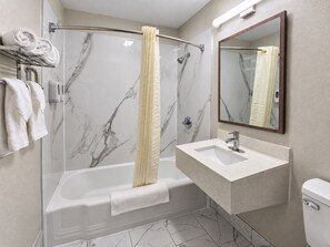 A modern bathroom with a glass-enclosed shower, a white sink, and a toilet. - Richmond Inn & Suites Near Dayton I-70 (Richmond)
