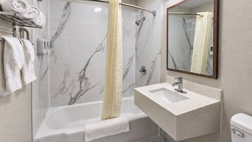 A modern bathroom with a glass-enclosed shower, a white sink, and a toilet.