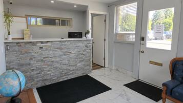 A reception area with a stone counter, a globe, a wooden desk, and a door leading outside.