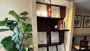 A reception area with a potted plant, a shelf displaying awards, and a clock. - Econo Lodge Lenoir City - Knoxville Area (Lenoir City)