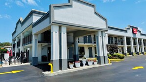 A hotel with a modern architectural design, featuring a prominent entrance with a covered area and potted plants. - Econo Lodge Lenoir City - Knoxville Area (Lenoir City)