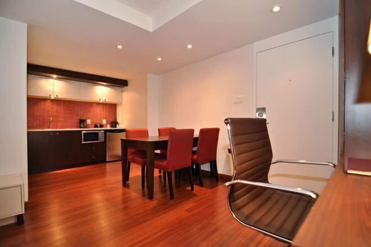 A modern kitchen with a dining area, including a table with chairs and a high chair.