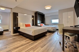 Una habitación de hotel con dos camas, un escritorio y una silla.