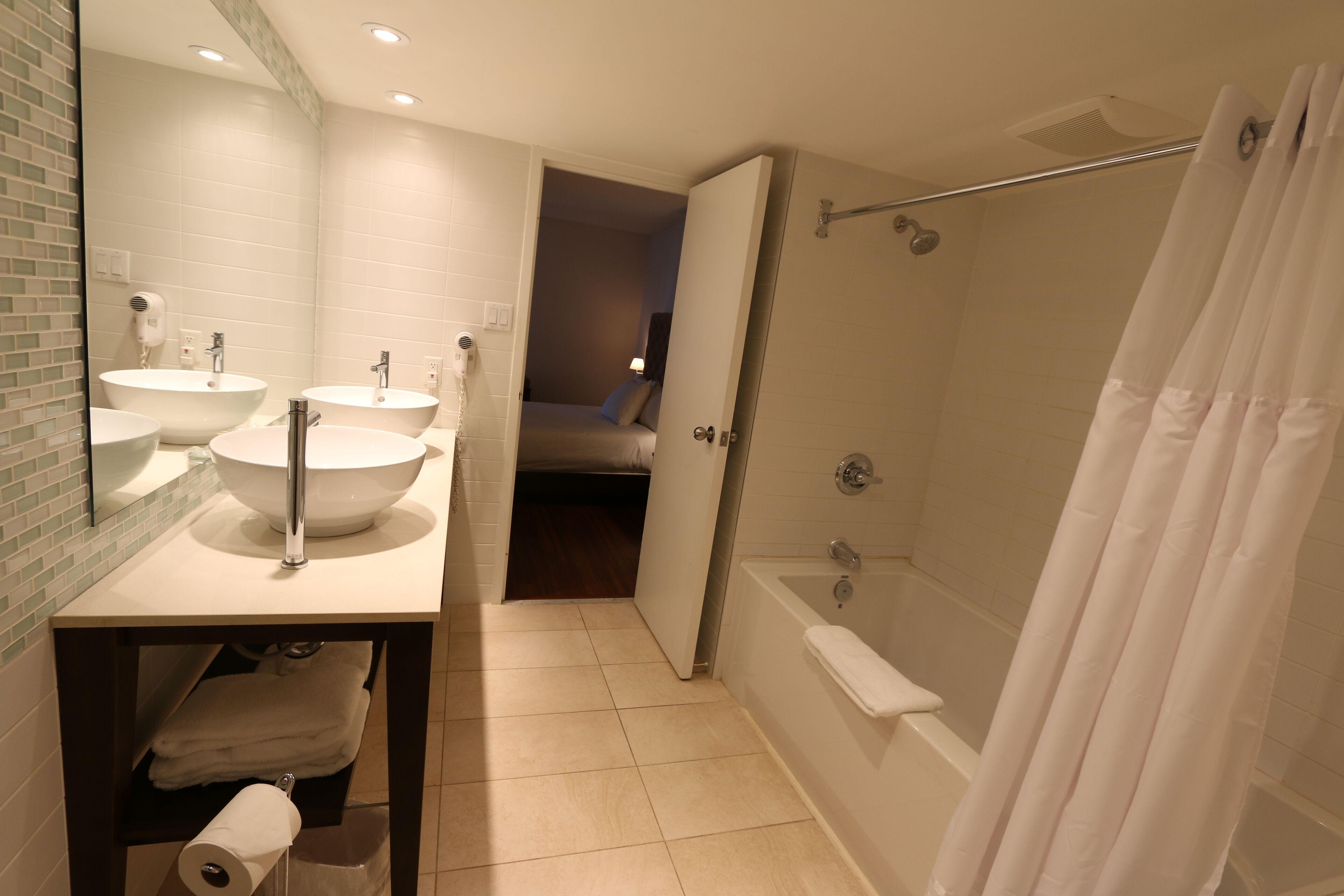 Une salle de bain moderne avec deux lavabos, une douche et des toilettes.
