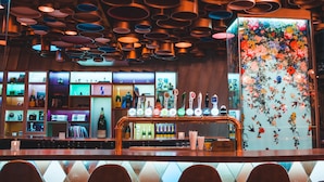 A bar area with multiple shelves displaying bottles and a variety of items. - Hotel Classique (Québec City)