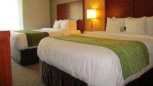 A hotel room with two beds, a nightstand, a lamp, and a window with curtains. - Comfort Inn Dartmouth (Dartmouth)