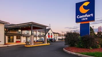 Un hotel Comfort Inn con un cartel grande, varios espacios de estacionamiento y una entrada cubierta.