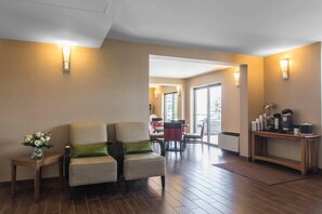 A hotel lobby with a seating area, a coffee station, and a view through a glass door. - Comfort Inn Dartmouth (Dartmouth)