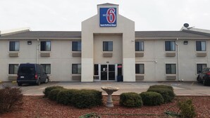 Un motel avec une enseigne bien visible, une allée et un espace de stationnement.