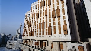 A tall building with a symmetrical facade, multiple windows, and a central courtyard.