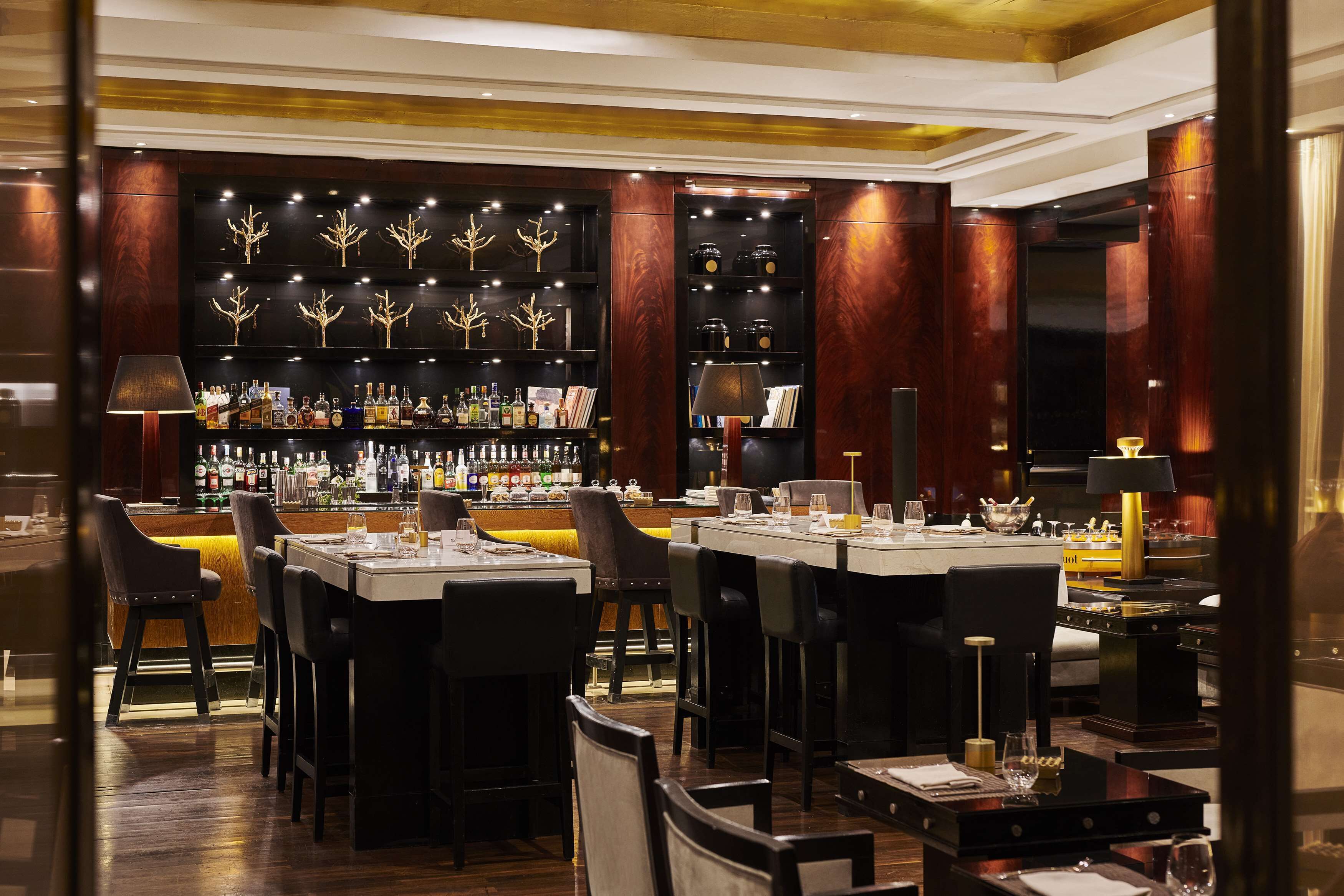A bar area with multiple seating arrangements and a well-stocked bar counter.