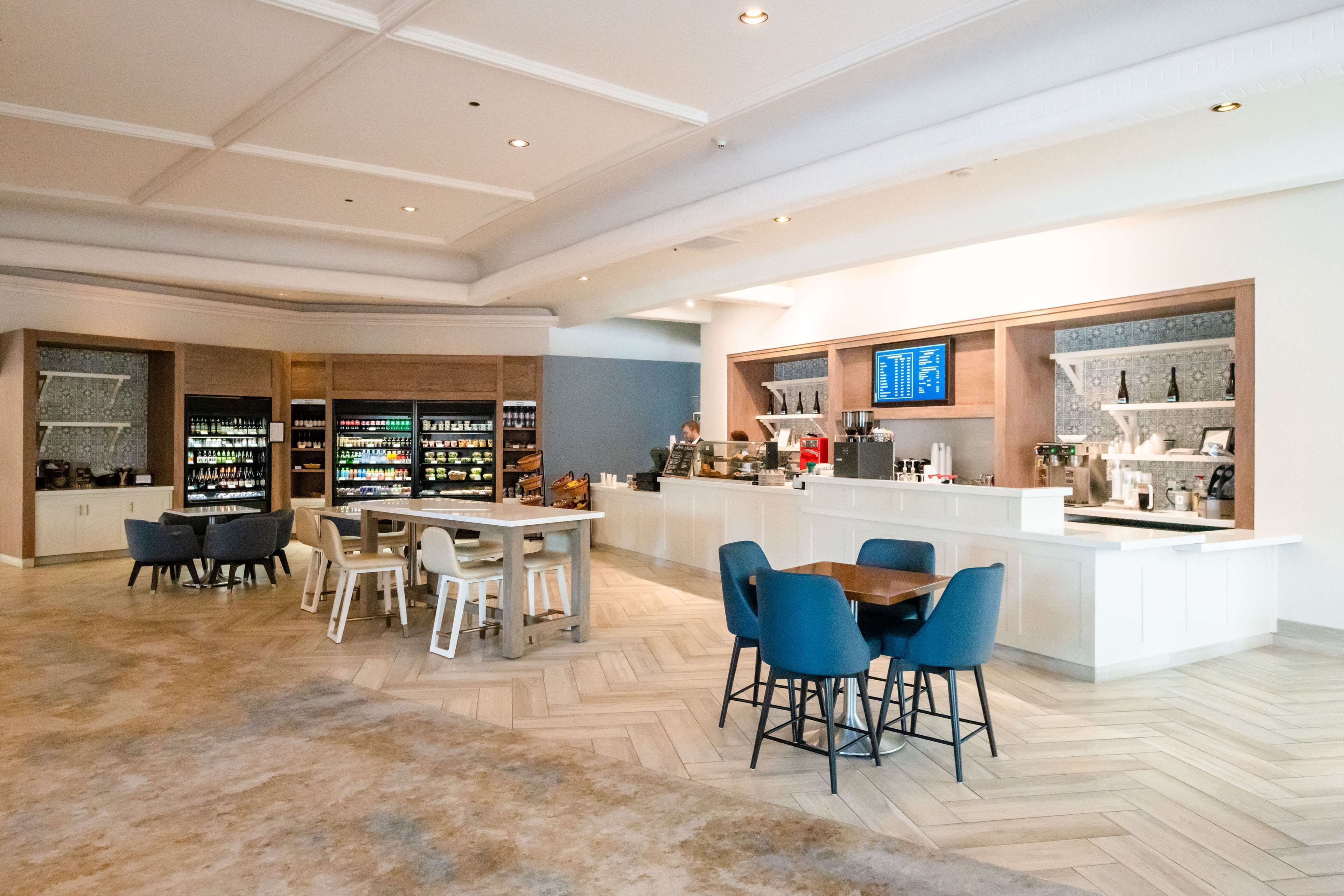 A spacious lobby with a central seating area, a bar, and a display of various items on shelves.