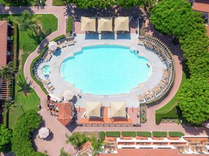 Relax by the resort's central pool, surrounded by lounge chairs and lush greenery.