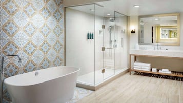 Une salle de bain moderne avec une baignoire sur pieds, une douche à parois de verre et un meuble-lavabo avec un miroir.
