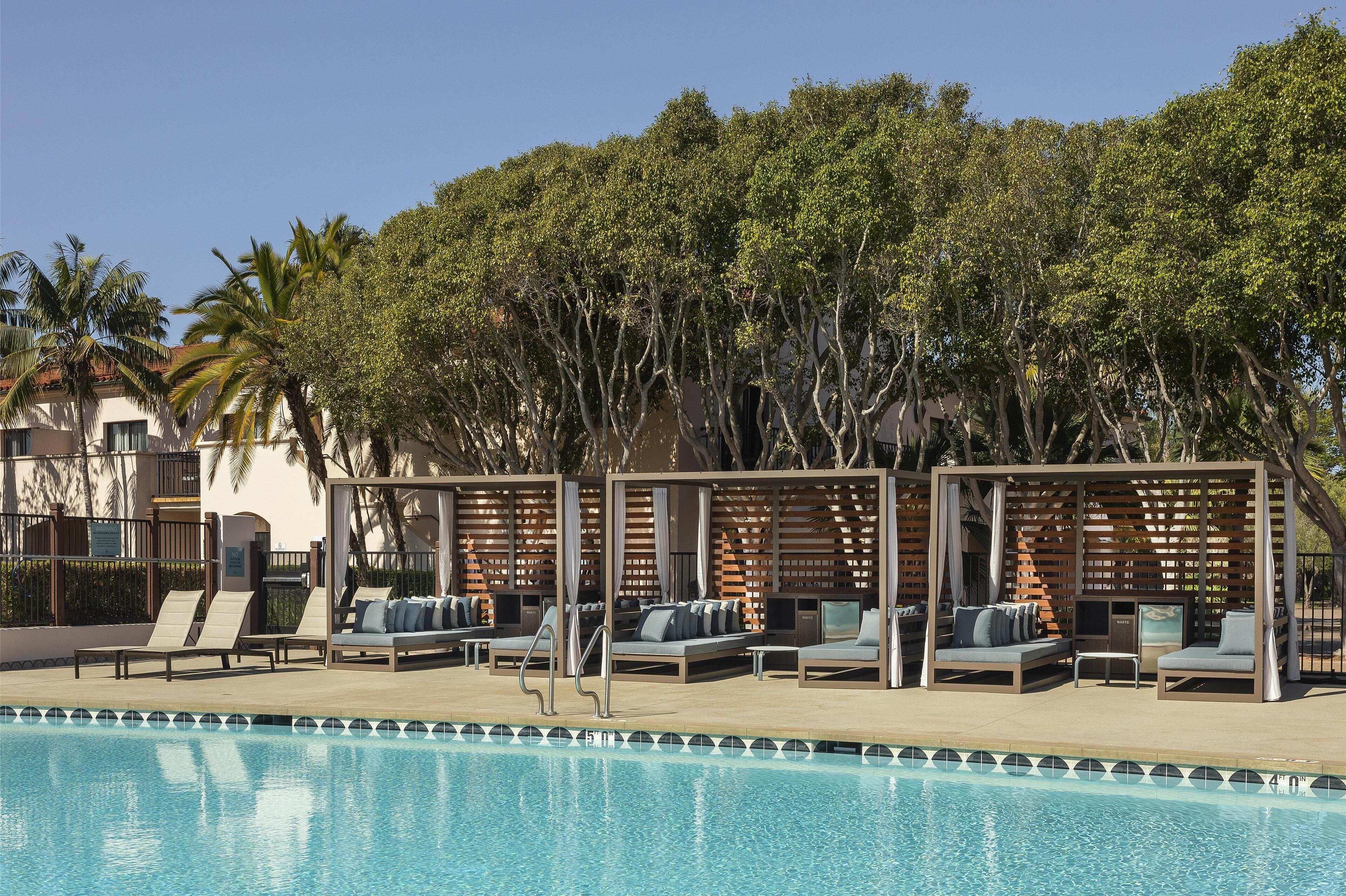 A poolside area with lounge chairs and a pergola.