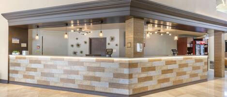 A reception area with a tiled counter, pendant lighting, and a digital payment terminal.