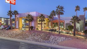 A hotel with a Best Western Plus sign, palm trees, and a well-lit entrance.
