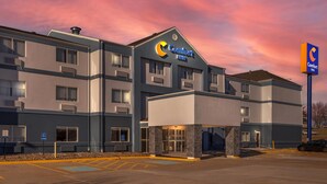 A Comfort Inn hotel with a modern design, featuring a prominent entrance and parking area.