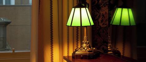 A room with a window, curtains, and two table lamps.