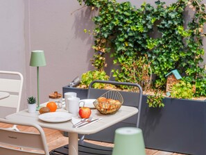 A table with breakfast items, a lamp, and a planter with greenery. - Mercure Colmar Centre Unterlinden (Colmar)