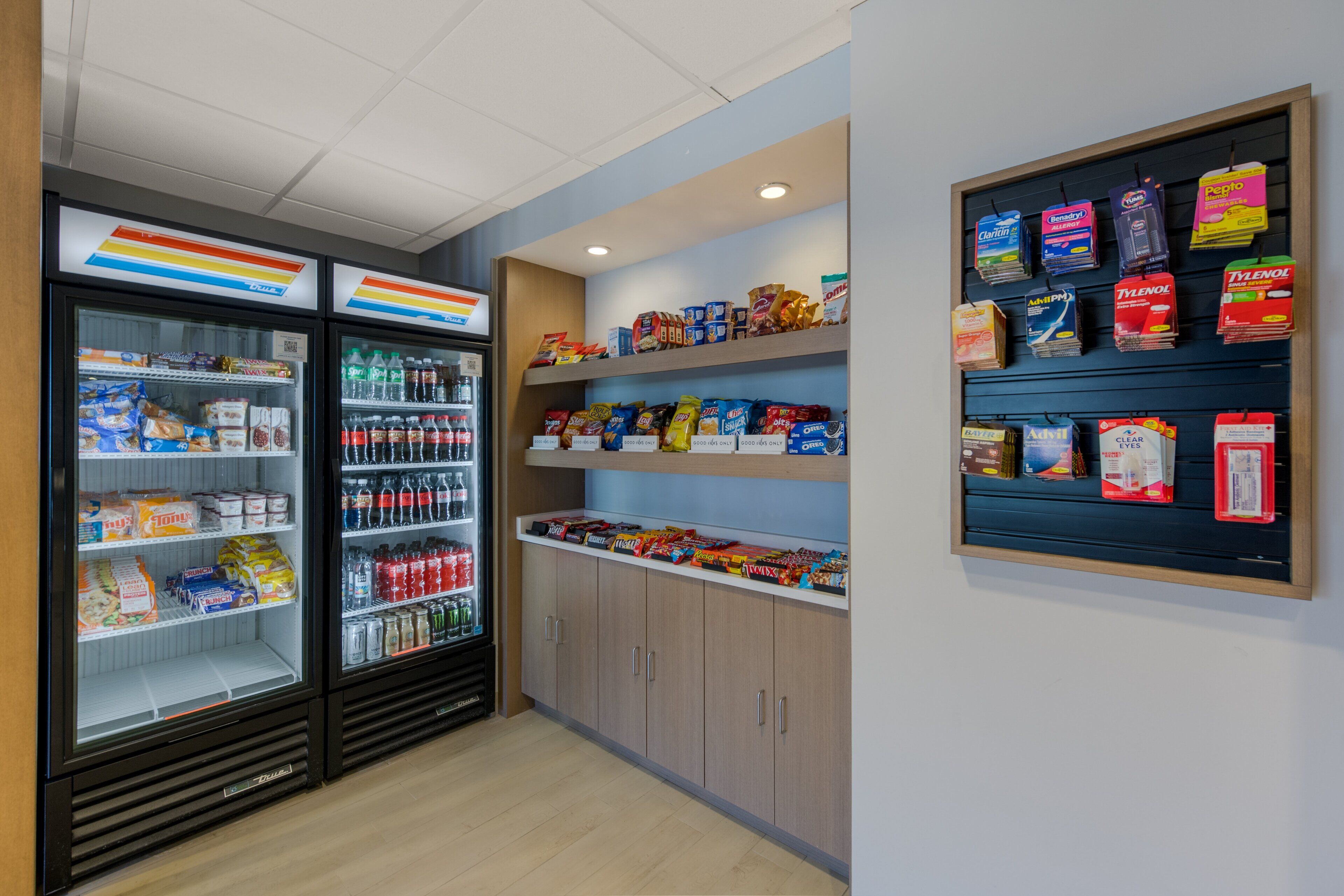 A clean, well-organized snack and beverage section with refrigerated drinks and a variety of snacks on shelves.