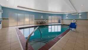 An indoor swimming pool with a tiled floor, clear pool area, and blue walls. - Holiday Inn Express Hampton - Coliseum Central by IHG (Hampton)