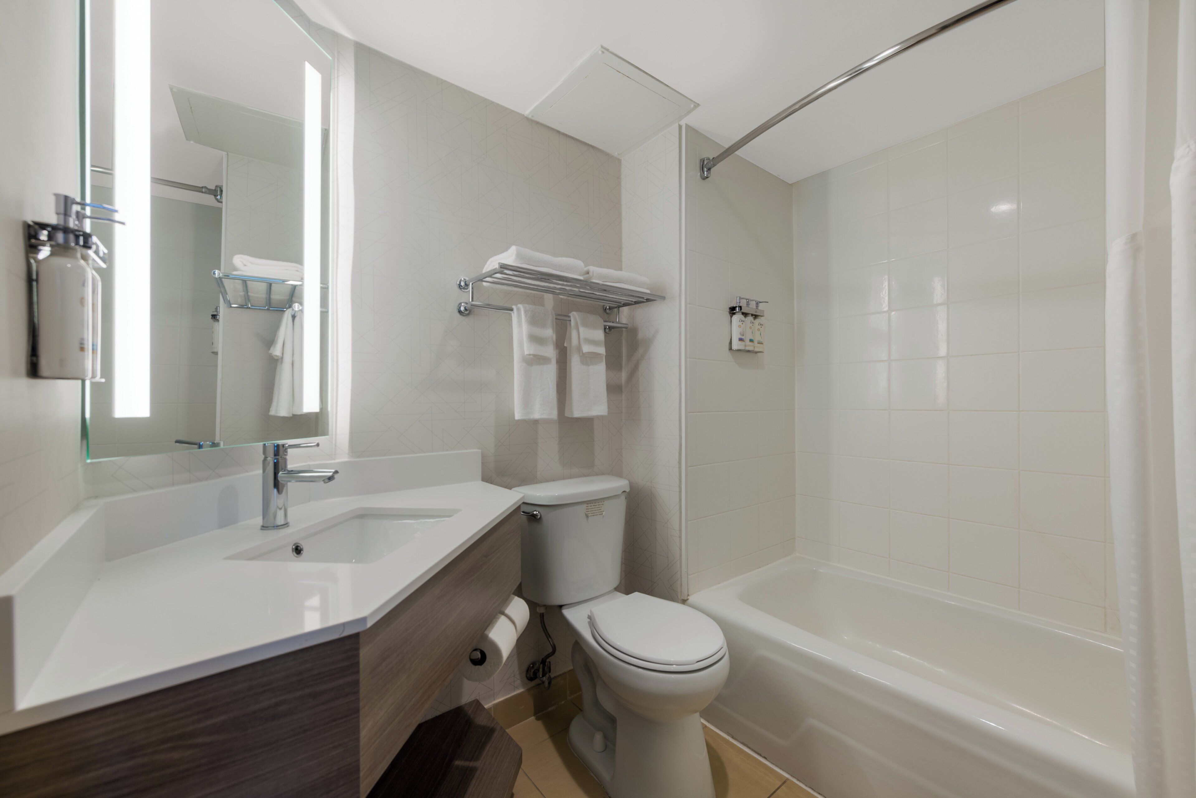 A modern bathroom with a shower, toilet, and vanity.