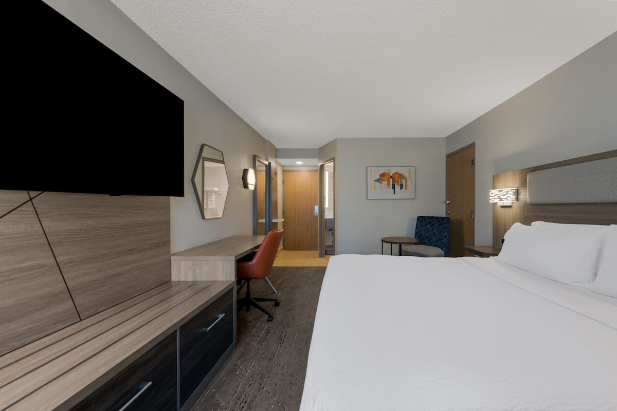 Relax in comfort with a large bed, flat-screen TV, and desk workspace.