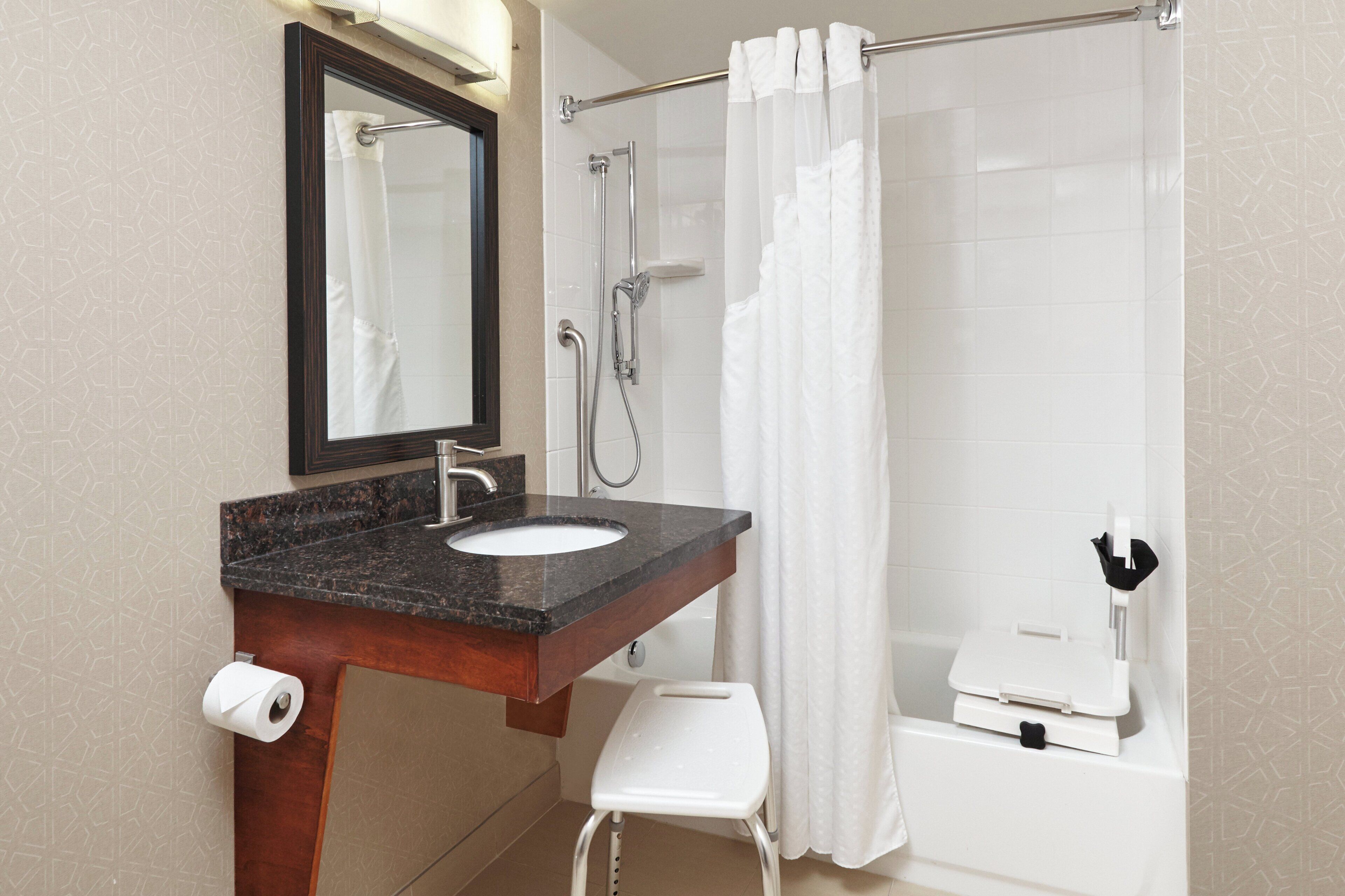 Ein Badezimmer mit Waschbecken, Spiegel, Dusche und Toilette.