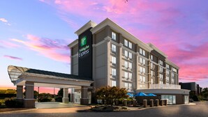 A Holiday Inn Express hotel with a covered entrance, multiple floors, and a parking area. - Holiday Inn Express Hampton - Coliseum Central by IHG (Hampton)