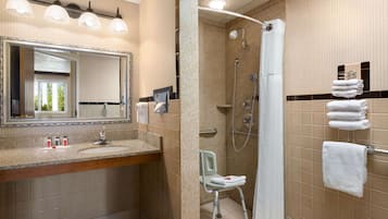 Een badkamer met een wastafel, spiegel, douche en een rolstoeltoegankige stoel.