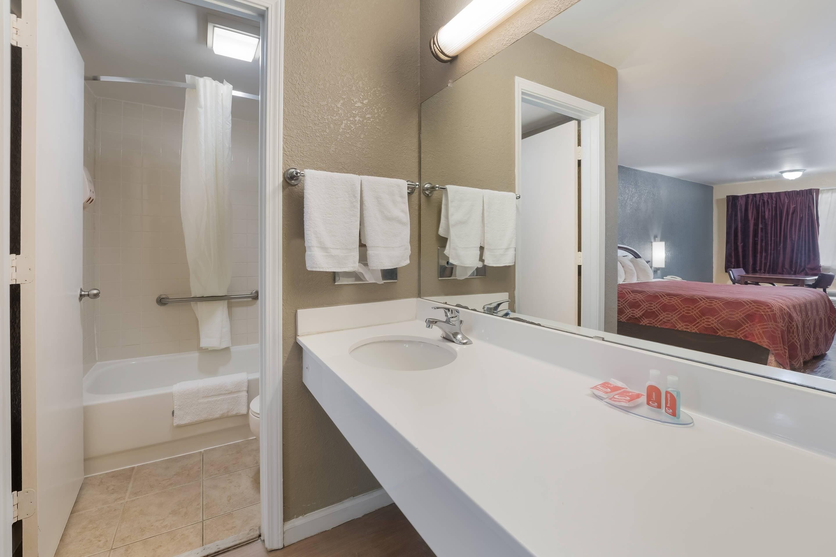 Een badkamer met een bad, een wastafel en een spiegel.