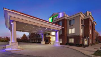 A Holiday Inn Express building with a covered outdoor area, brick facade, and a sign indicating the hotel name.