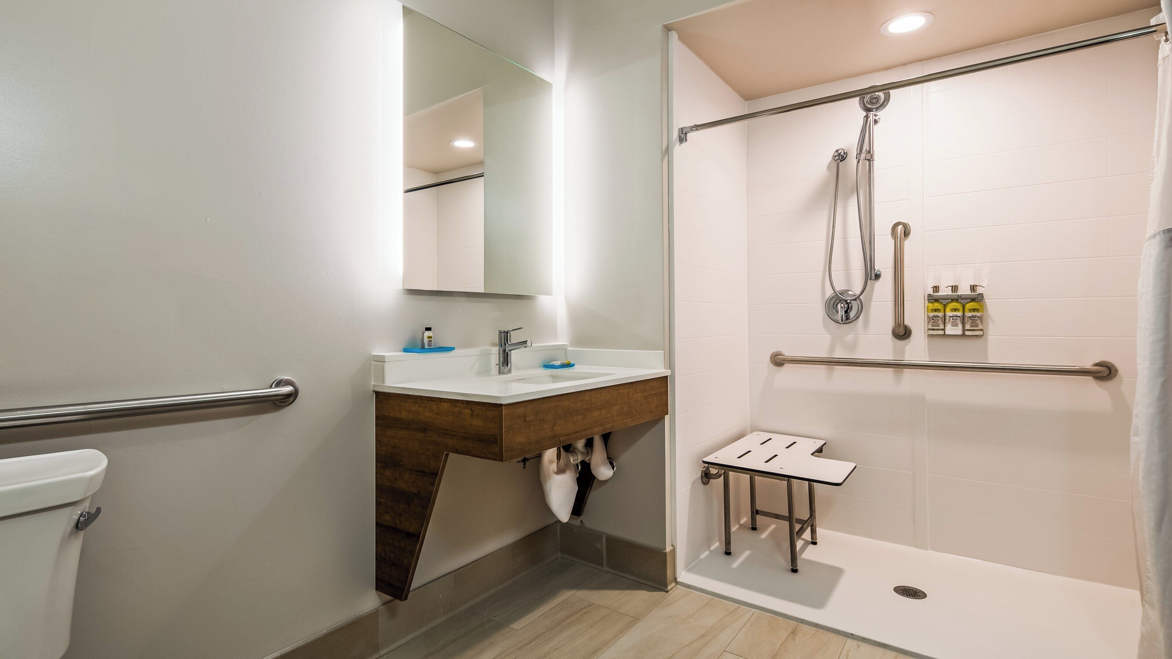 A modern bathroom with a shower, toilet, and sink.