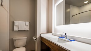 Une salle de bain moderne équipée de toilettes, d’un lavabo et d’un miroir.