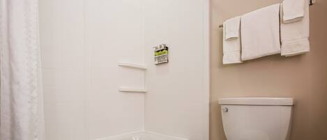A bathroom with a bathtub, toilet, and towel rack.
