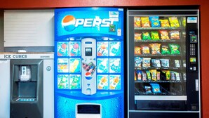 Un distributeur automatique orné du logo Pepsi et proposant un assortiment de collations.