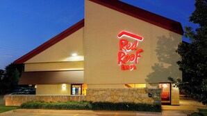 A building with a 'Red Roof Inn' sign, a stone facade, and a visible lobby entrance.
