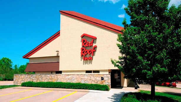 A building with a red roof and a sign that reads 'Red Roof Inn.'