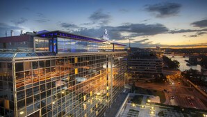 Un hôtel moderne doté d’une façade en verre et d’une enseigne « Hilton » bien visible.