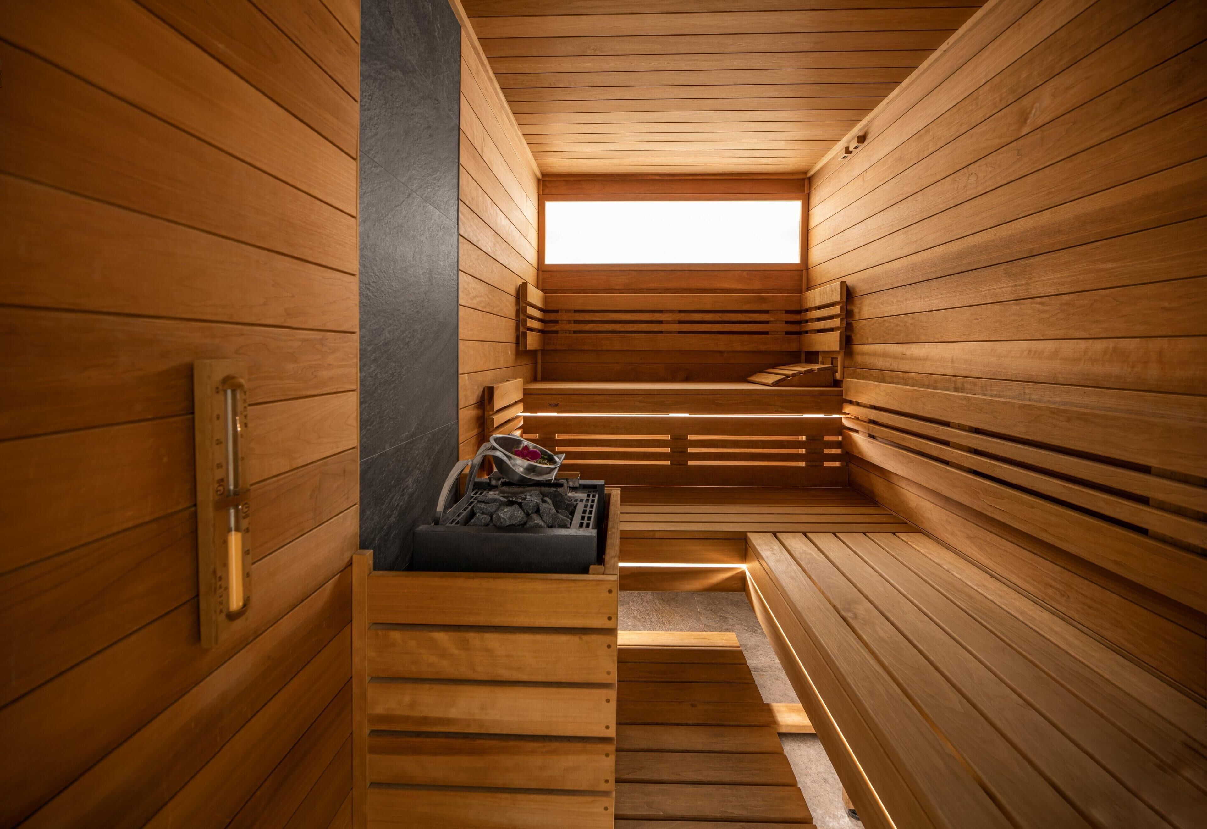 A wooden sauna with benches and a stone bench.
