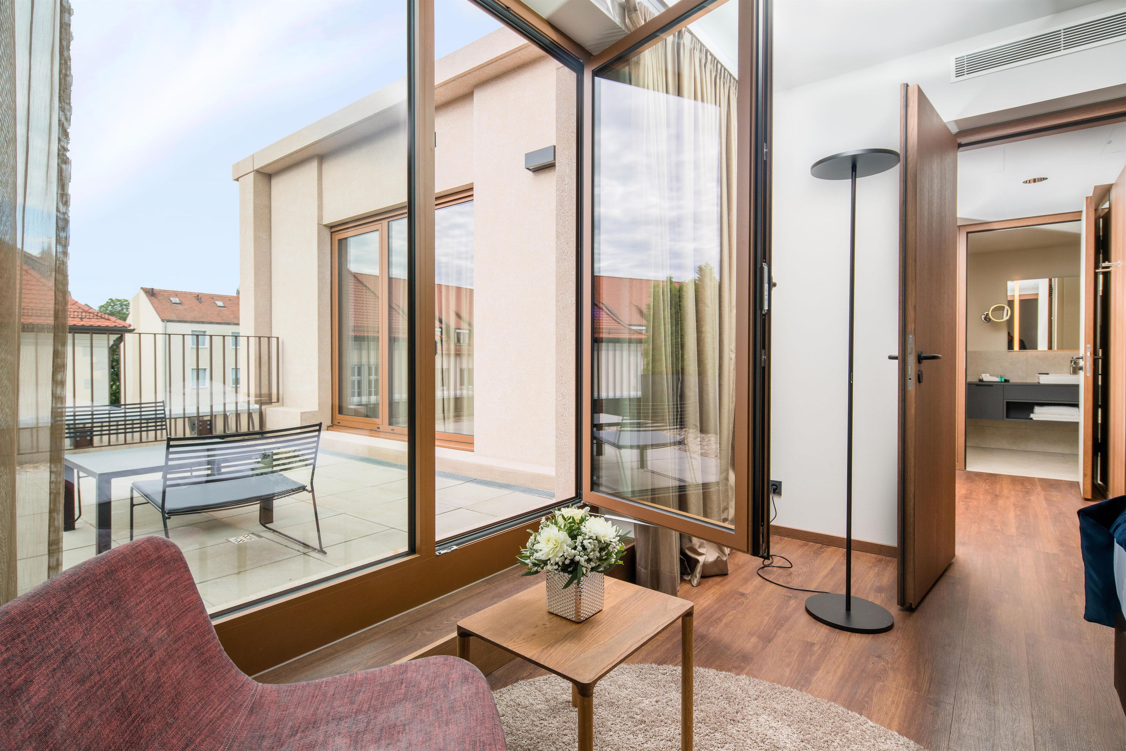 A modern interior with a large sliding glass door leading to an outdoor patio area.